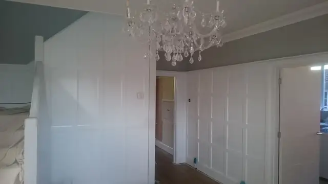 White panelled landing with a chandelier