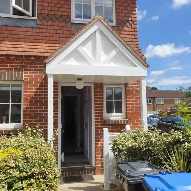 White painted porch and front door on a brick house