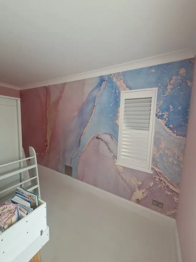 Pink and blue marble mural wallpaper on a bedroom wall